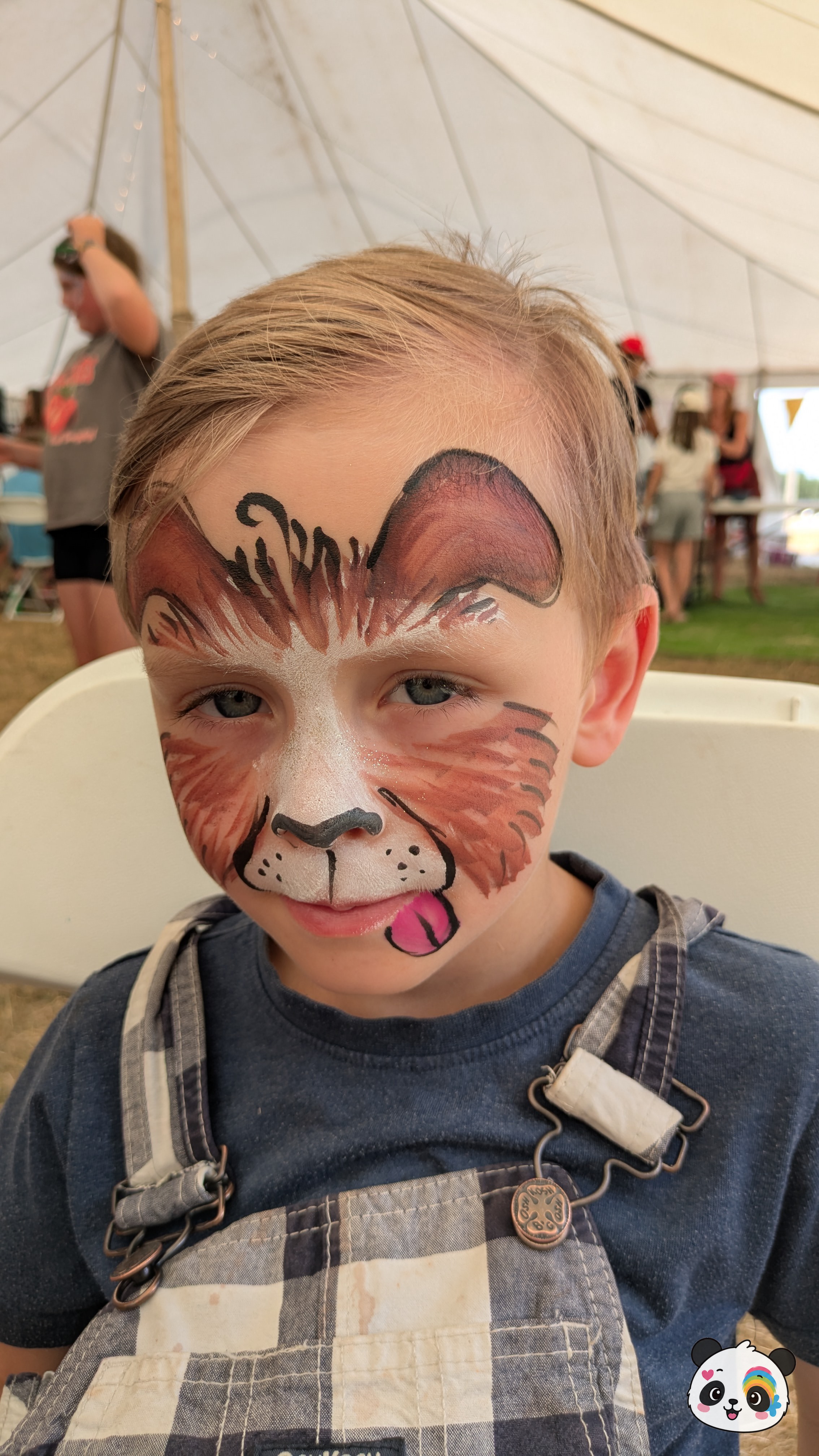 Brown and white puppy dog face paint covering the forehead and cheeks, featuring floppy ears, a black nose, and a small pink tongue sticking out.