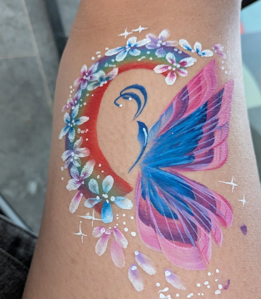 Colourful butterfly and rainbow arm painting with white flowers