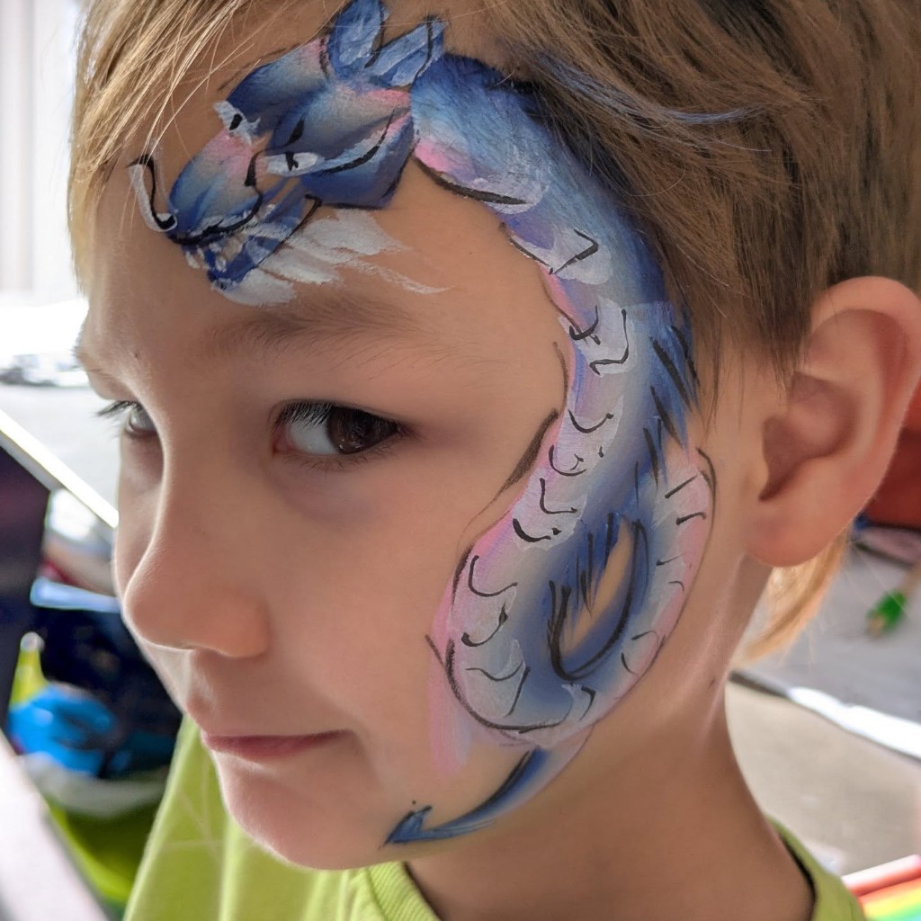 Blue and purple dragon face paint curling across a child's face