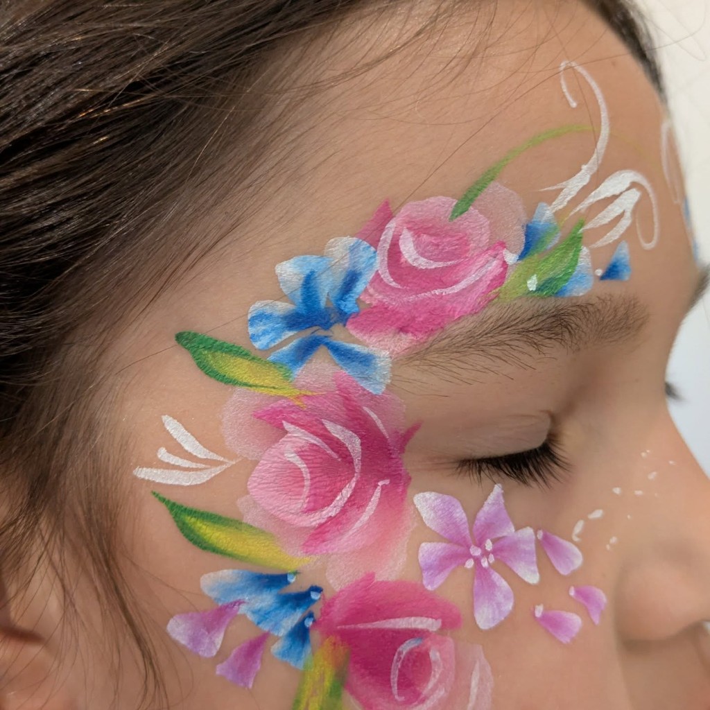Pink roses and blue flowers painted around a child's eye