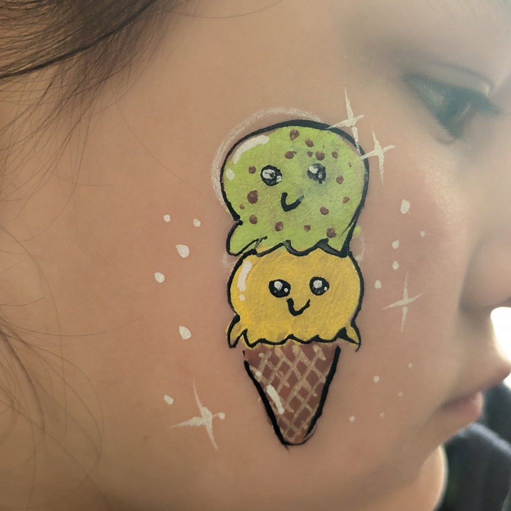 Kawaii ice cream cone face paint on a child's cheek